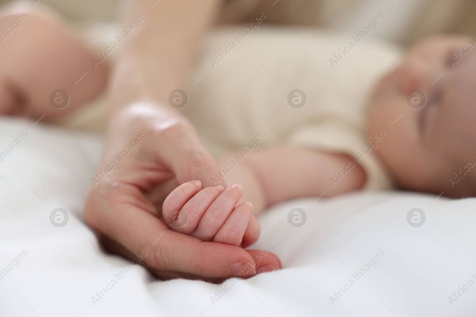 Mother with her newborn baby on bed indoors, closeup Photo of Mother with her newborn baby on bed indoors, closeup