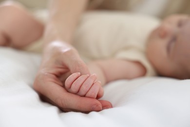 Photo of Mother with her newborn baby on bed indoors, closeup