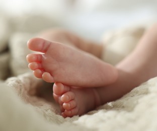 Photo of Cute newborn baby lying on bed indoors, closeup