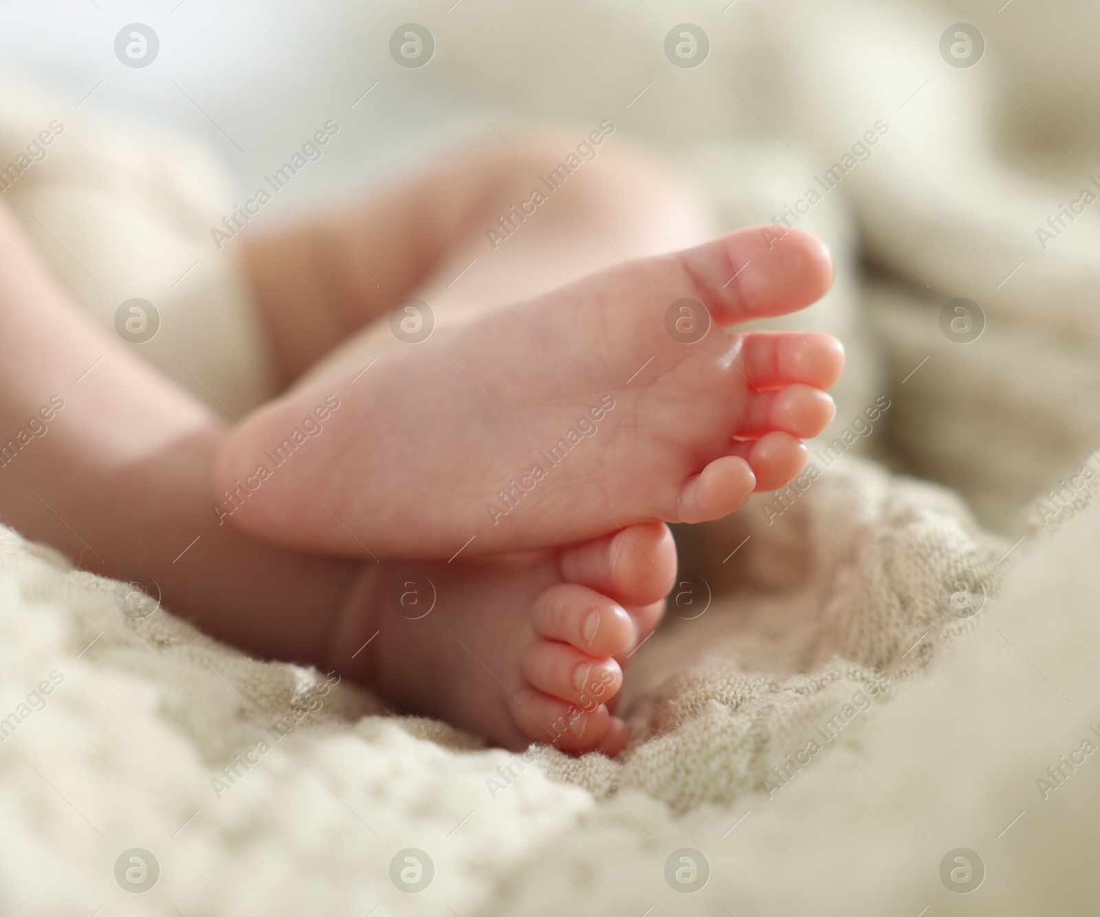 Cute newborn baby lying on bed indoors, closeup Photo of Cute newborn baby lying on bed indoors, closeup