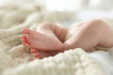 Photo of Cute newborn baby lying on bed indoors, closeup