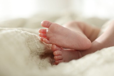 Photo of Cute newborn baby lying on bed indoors, closeup