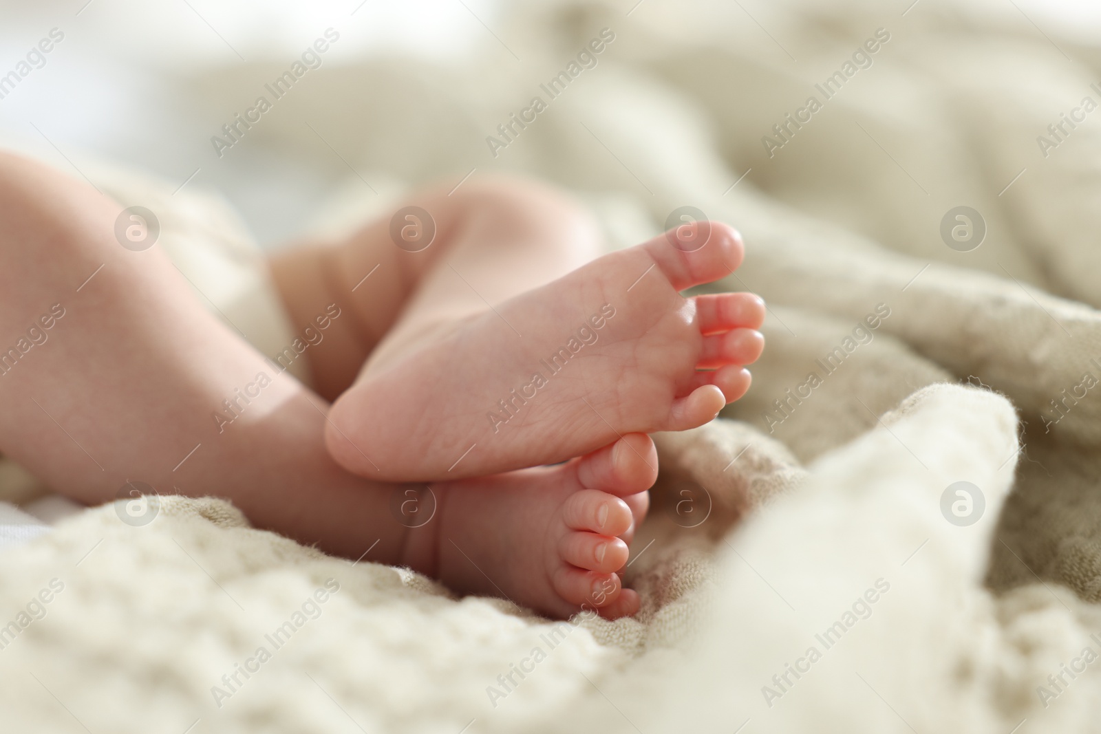Cute newborn baby lying on bed indoors, closeup Photo of Cute newborn baby lying on bed indoors, closeup