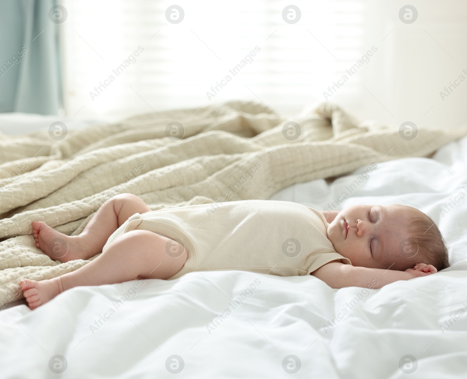 Cute newborn baby sleeping on bed indoors Photo of Cute newborn baby sleeping on bed indoors