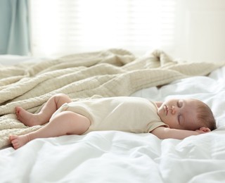 Photo of Cute newborn baby sleeping on bed indoors