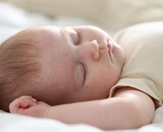 Photo of Cute newborn baby sleeping on bed indoors