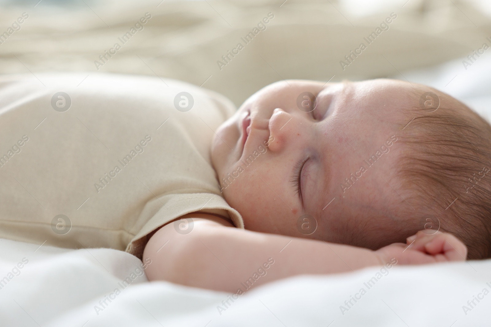 Cute newborn baby sleeping on bed indoors Photo of Cute newborn baby sleeping on bed indoors