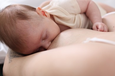Photo of Mother breastfeeding her newborn baby indoors, above view