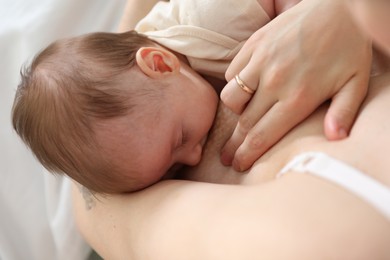 Photo of Mother breastfeeding her newborn baby indoors, above view