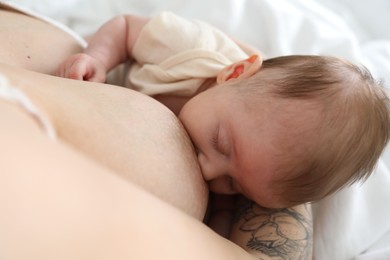 Photo of Mother breastfeeding her newborn baby indoors, above view