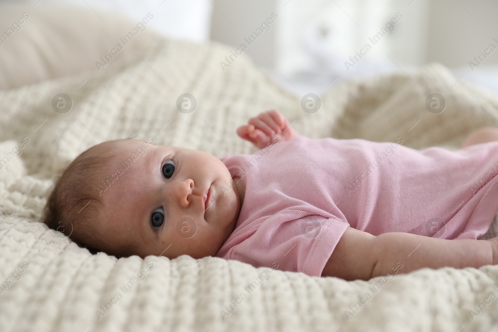 Cute newborn baby lying on bed indoors Photo of Cute newborn baby lying on bed indoors