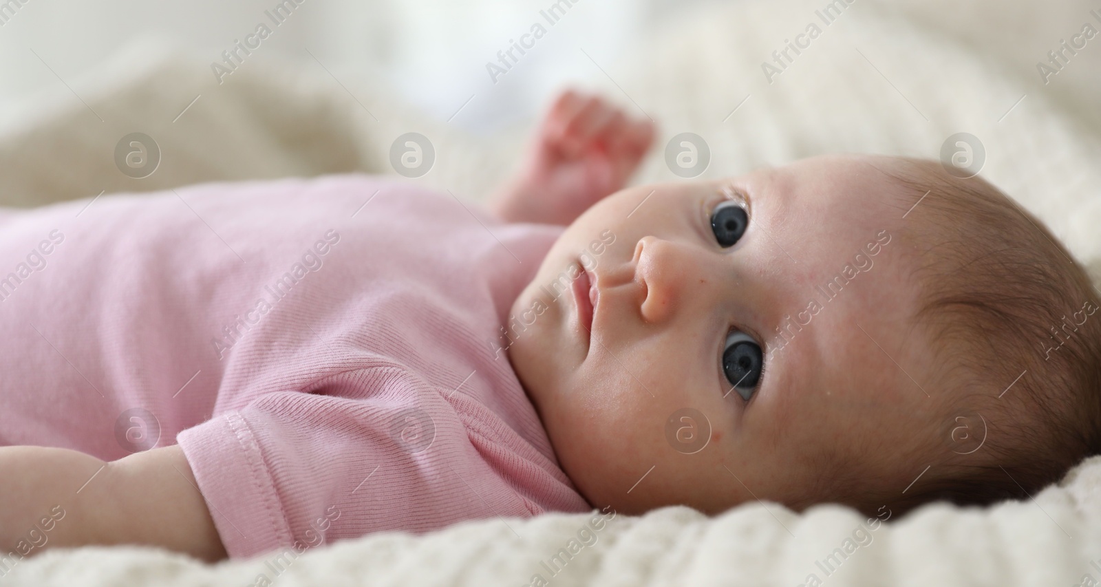 Cute newborn baby lying on bed indoors Photo of Cute newborn baby lying on bed indoors