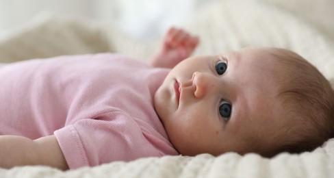 Photo of Cute newborn baby lying on bed indoors