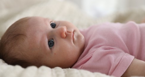 Photo of Cute newborn baby lying on bed indoors