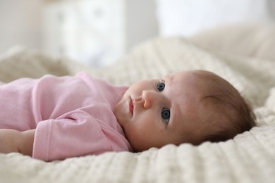 Photo of Cute newborn baby lying on bed indoors