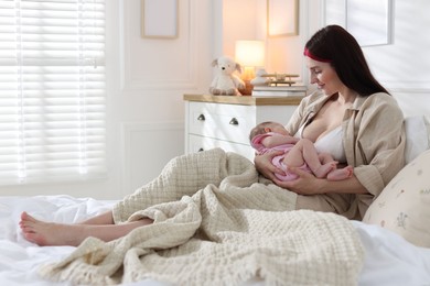 Photo of Mother with her newborn baby on bed indoors