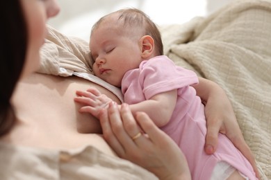 Photo of Mother with her newborn baby indoors, closeup