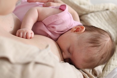 Photo of Mother breastfeeding her newborn baby indoors, above view