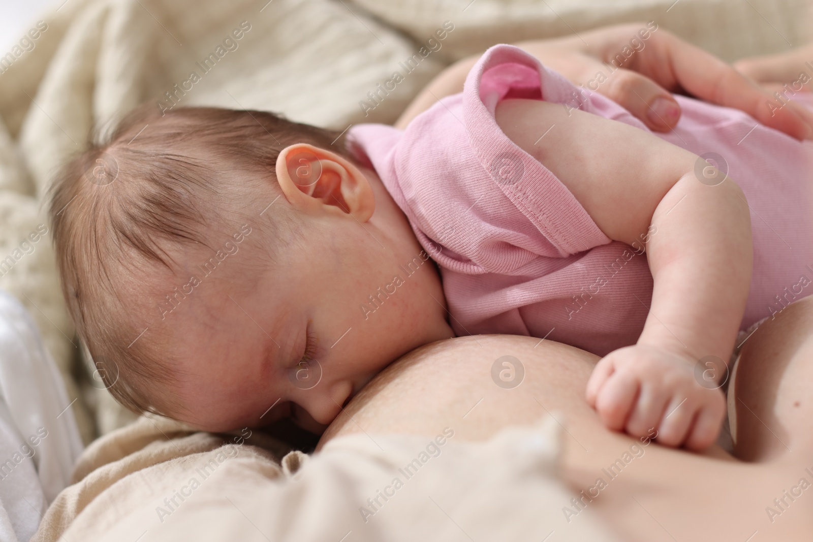Mother breastfeeding her newborn baby indoors, above view Photo of Mother breastfeeding her newborn baby indoors, above view