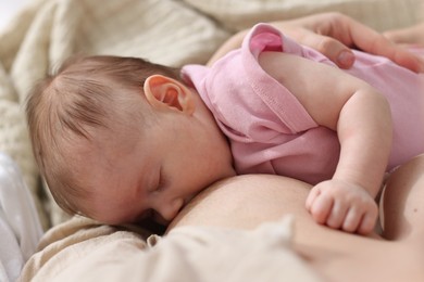 Photo of Mother breastfeeding her newborn baby indoors, above view