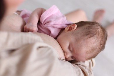 Photo of Mother breastfeeding her newborn baby indoors, above view