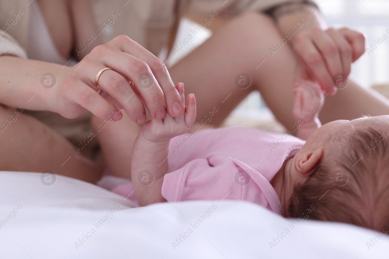 Photo of Mother with her newborn baby on bed at home, closeup