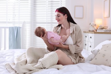 Photo of Mother with her newborn baby on bed indoors