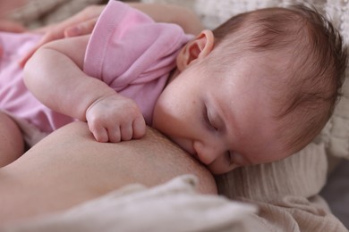 Photo of Mother breastfeeding her newborn baby indoors, above view