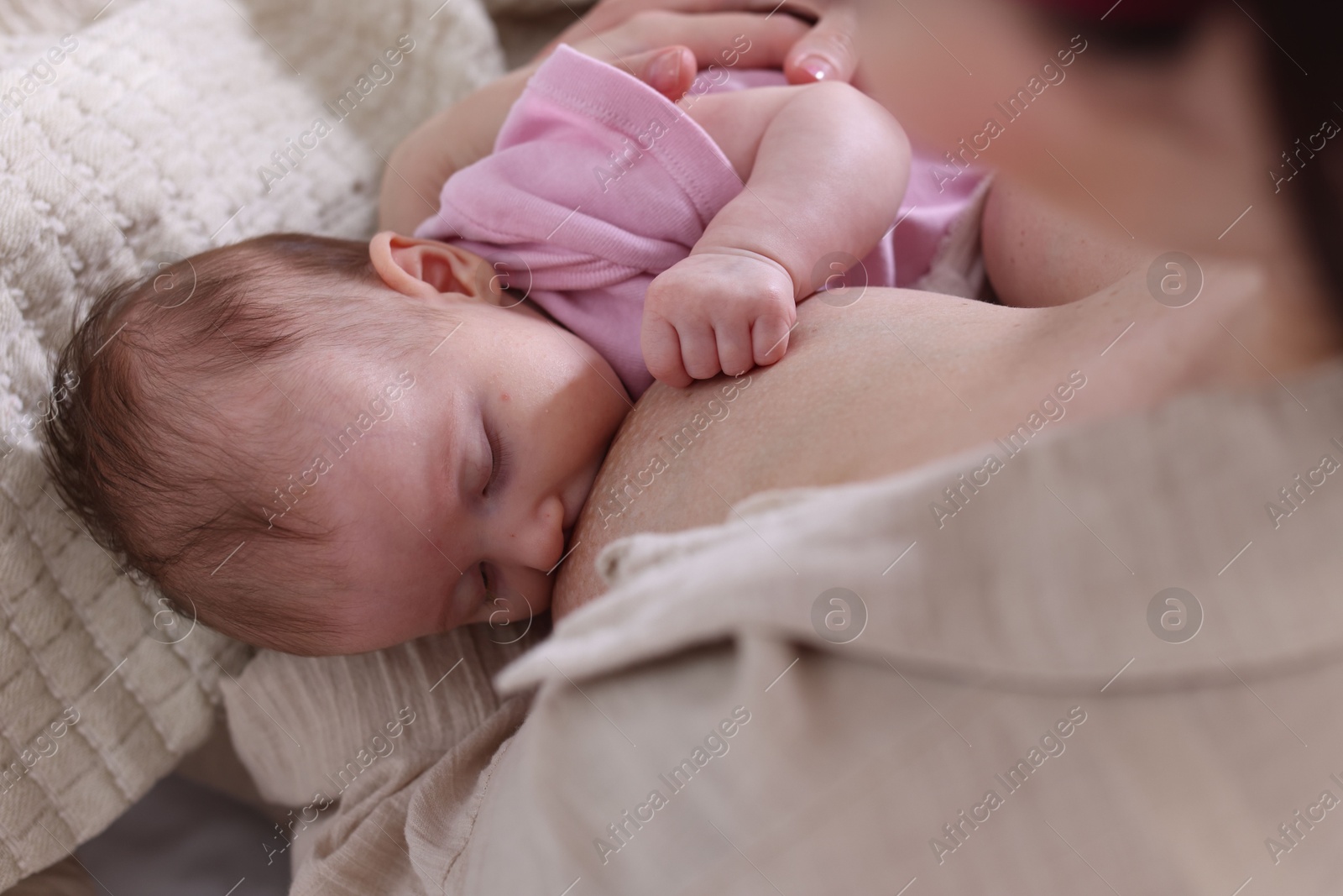 Mother breastfeeding her newborn baby indoors, above view Photo of Mother breastfeeding her newborn baby indoors, above view