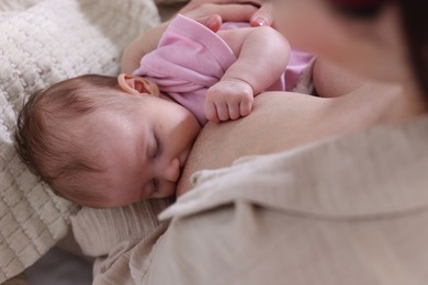 Photo of Mother breastfeeding her newborn baby indoors, above view