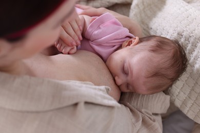 Photo of Mother breastfeeding her newborn baby indoors, above view