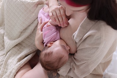 Photo of Mother breastfeeding her newborn baby indoors, above view