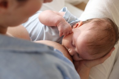 Photo of Mother breastfeeding her newborn baby indoors, above view