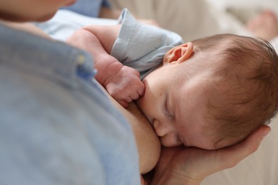 Photo of Mother breastfeeding her newborn baby indoors, above view