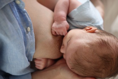 Photo of Mother breastfeeding her newborn baby indoors, above view