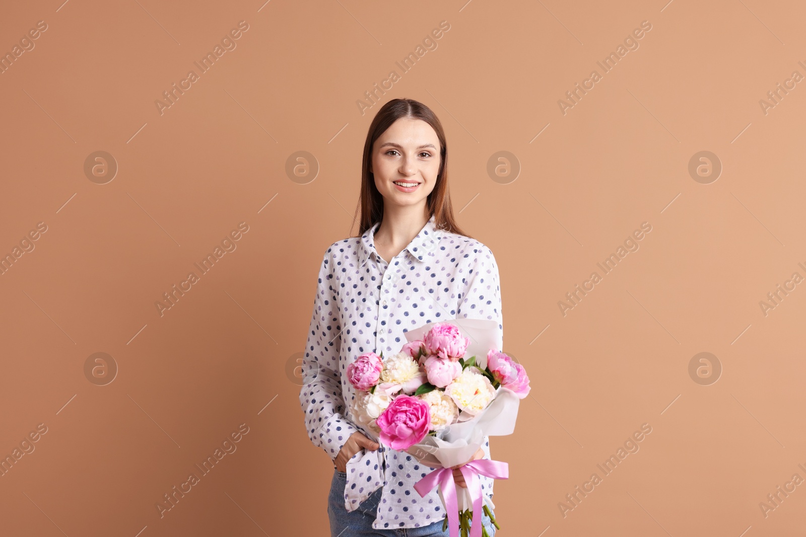 Woman with beautiful bouquet of peonies on dark beige background Photo of Woman with beautiful bouquet of peonies on dark beige background