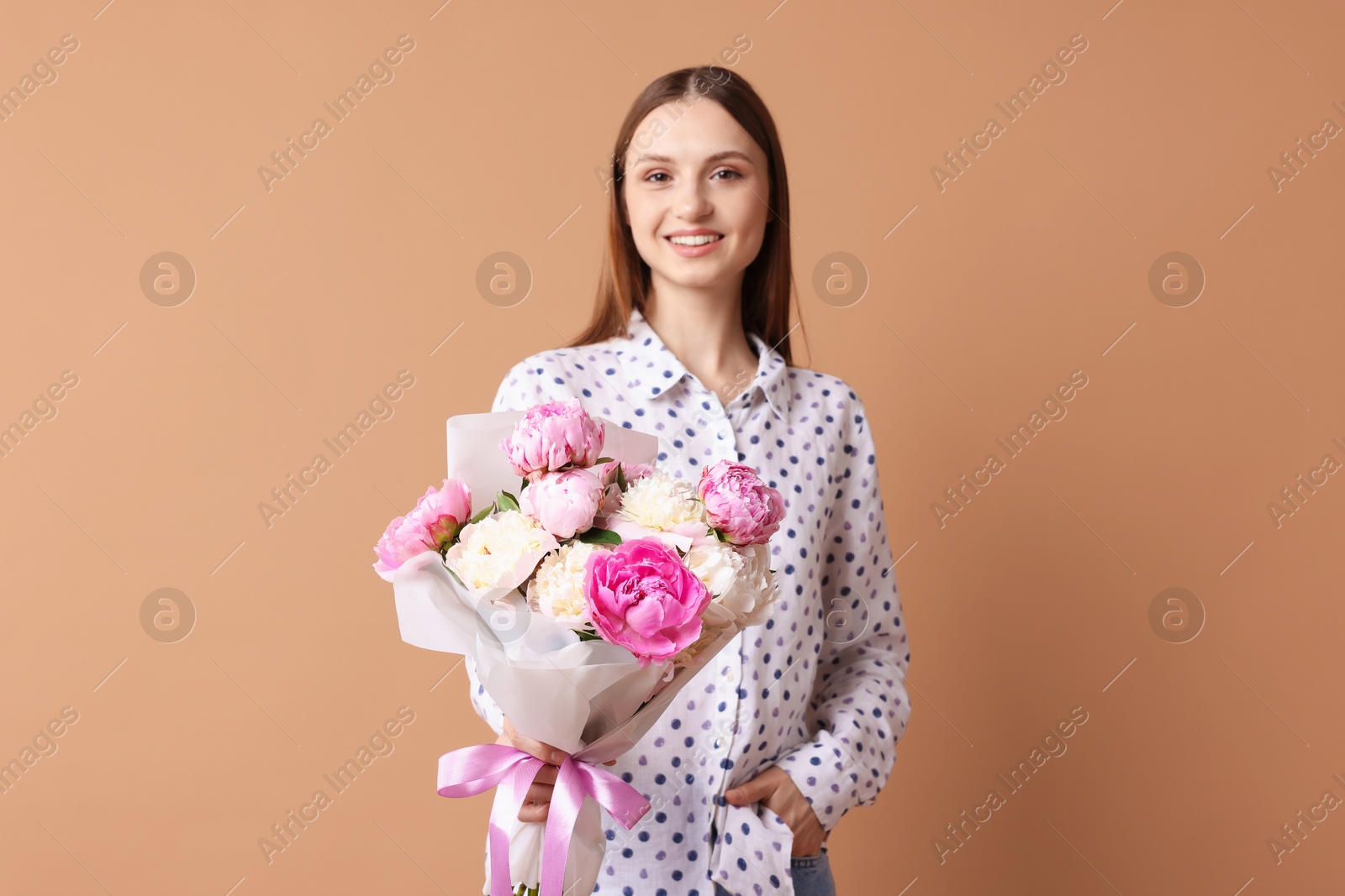 Woman with beautiful bouquet of peonies on dark beige background Photo of Woman with beautiful bouquet of peonies on dark beige background