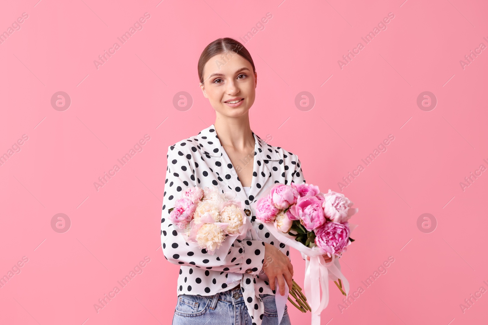 Woman with beautiful bouquets of peonies on pink background Photo of Woman with beautiful bouquets of peonies on pink background