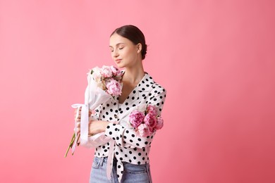 Photo of Woman with beautiful bouquets of peonies on pink background