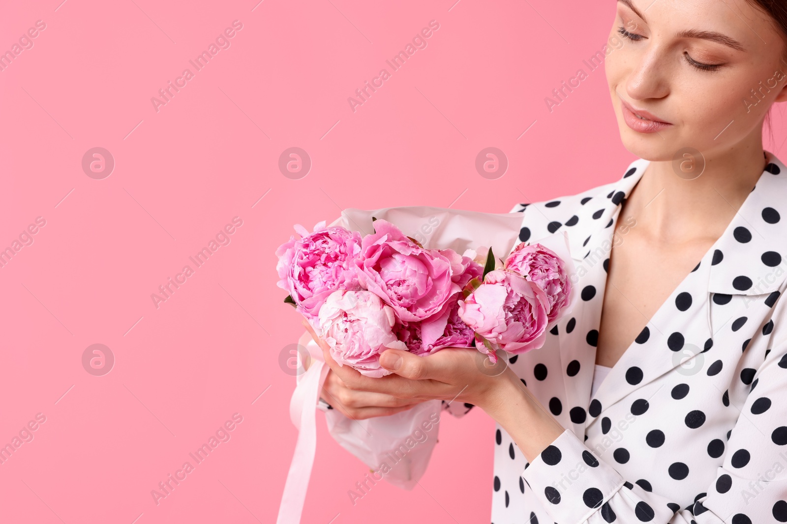 Woman with beautiful bouquet of peonies on pink background, space for text Photo of Woman with beautiful bouquet of peonies on pink background, space for text