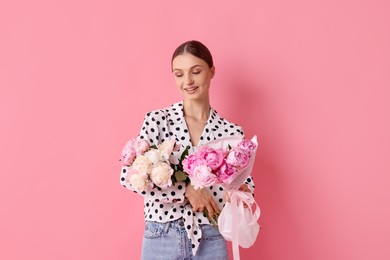 Photo of Woman with beautiful bouquets of peonies on pink background