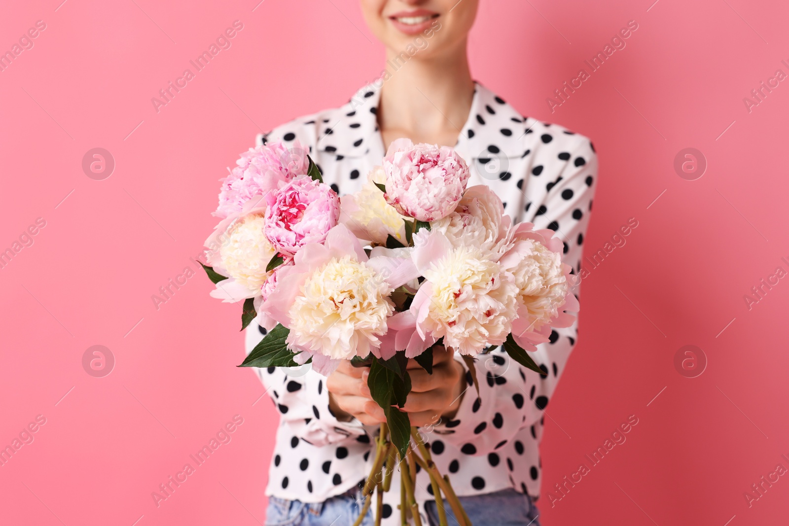 Woman with beautiful bouquet of peonies on pink background, closeup Photo of Woman with beautiful bouquet of peonies on pink background, closeup