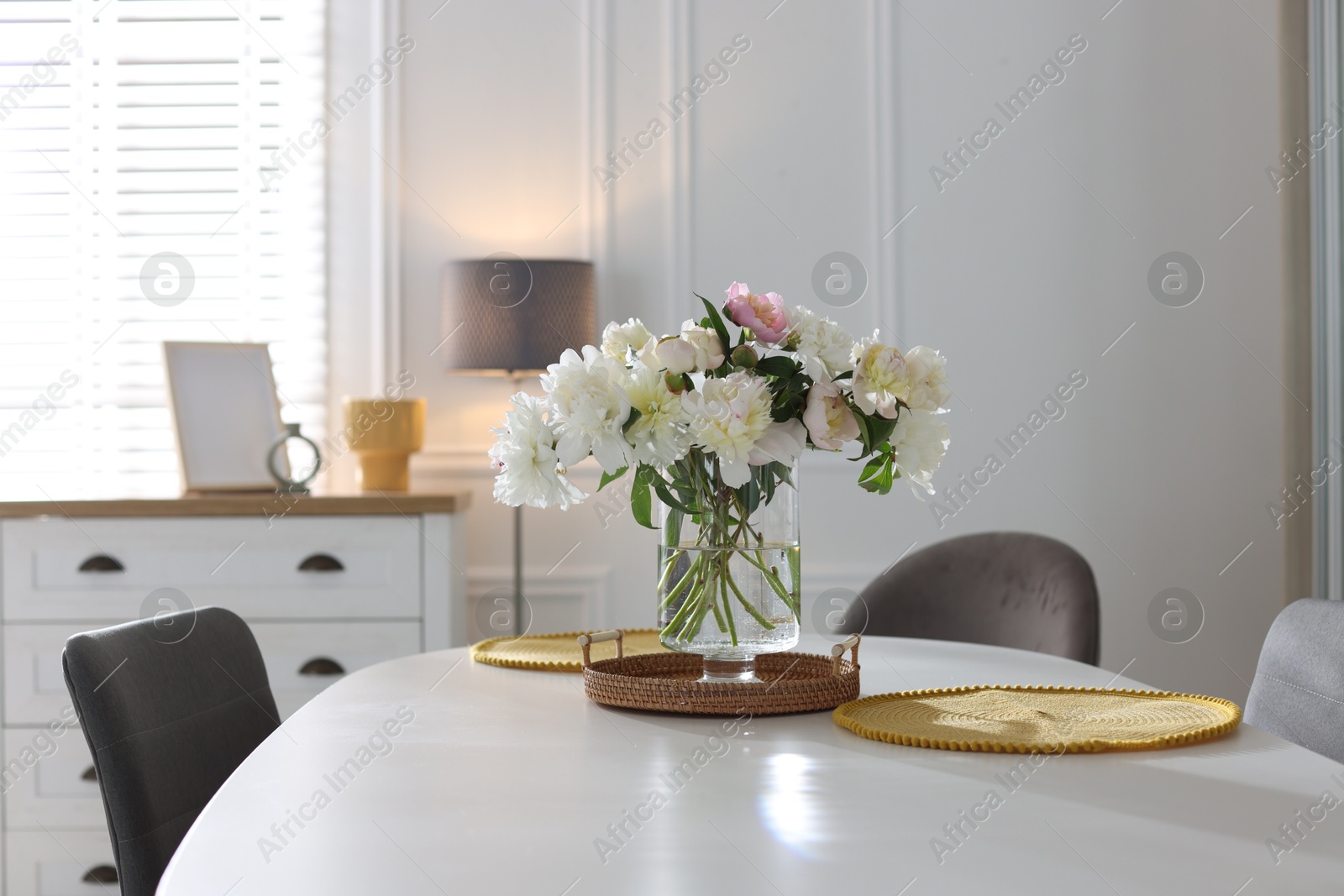 Beautiful table setting with vase of flowers in dining room Photo of Beautiful table setting with vase of flowers in dining room
