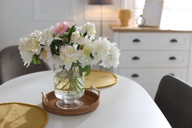 Photo of Beautiful table setting with vase of flowers in dining room, space for text