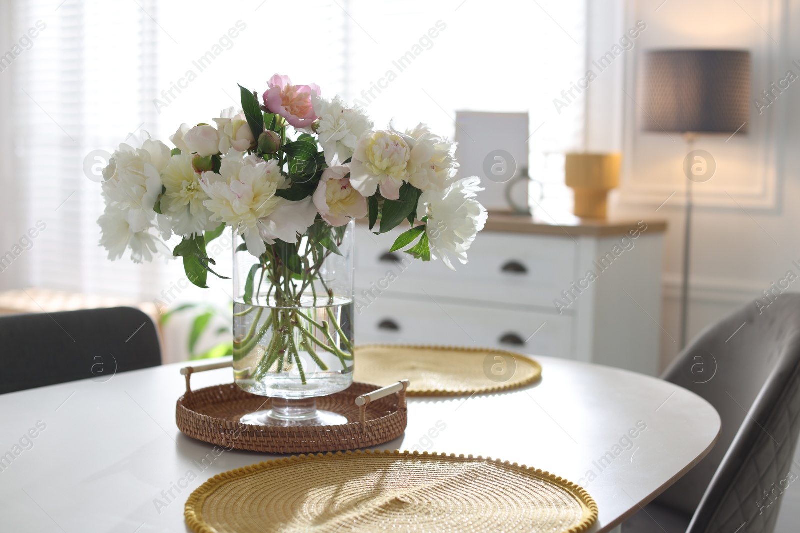 Beautiful table setting with vase of flowers in dining room Photo of Beautiful table setting with vase of flowers in dining room