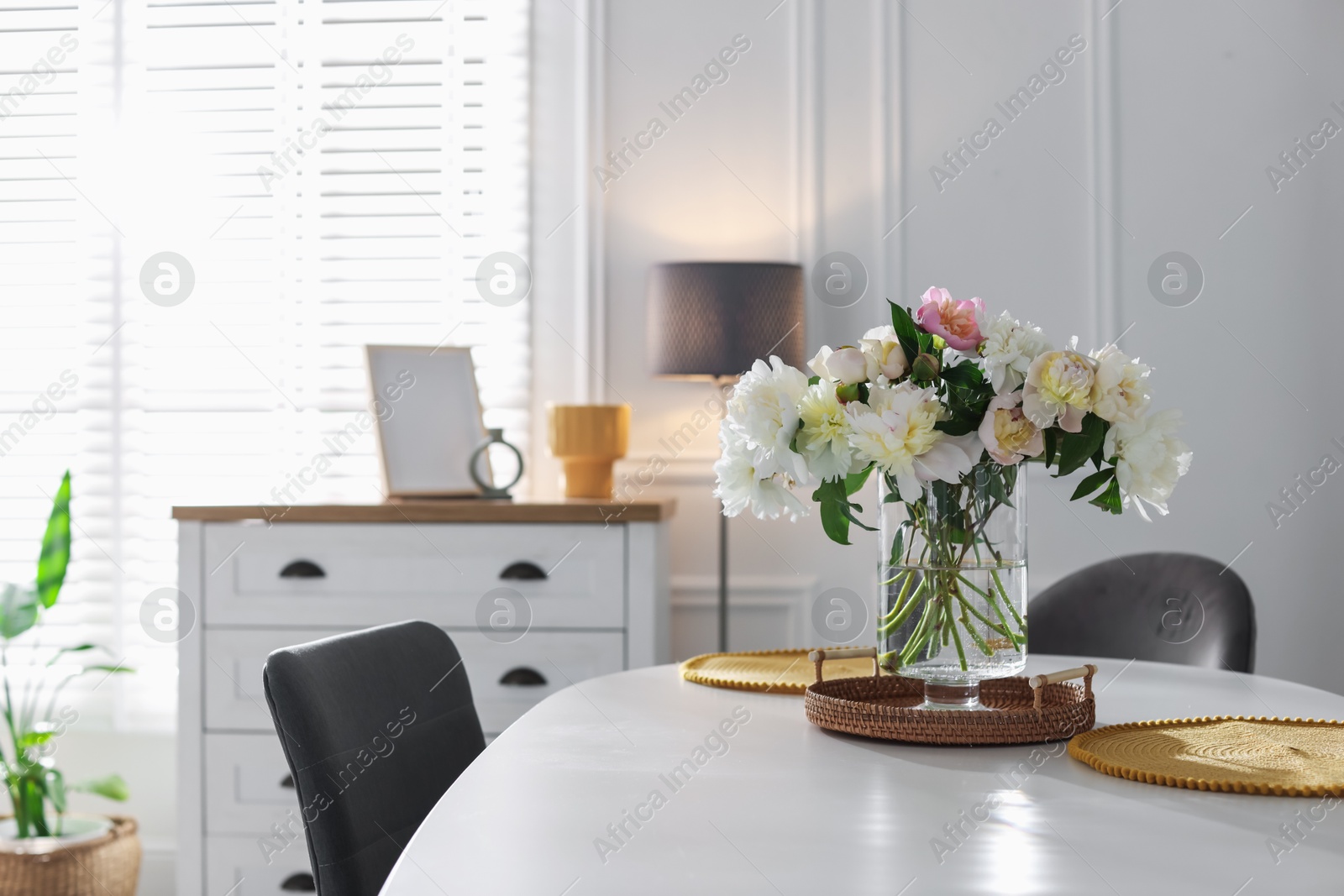 Beautiful table setting with vase of flowers in dining room, space for text Photo of Beautiful table setting with vase of flowers in dining room, space for text