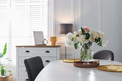Photo of Beautiful table setting with vase of flowers in dining room, space for text