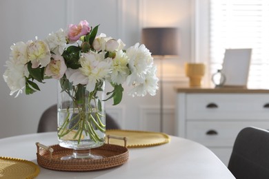 Photo of Beautiful table setting with vase of flowers in dining room, space for text