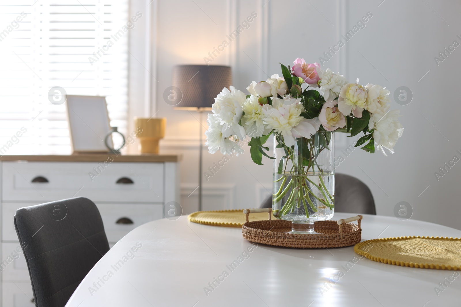 Beautiful table setting with vase of flowers in dining room, space for text Photo of Beautiful table setting with vase of flowers in dining room, space for text