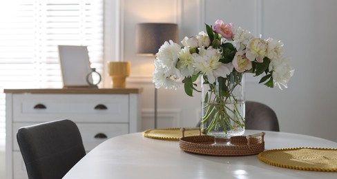 Photo of Beautiful table setting with vase of flowers in dining room, space for text